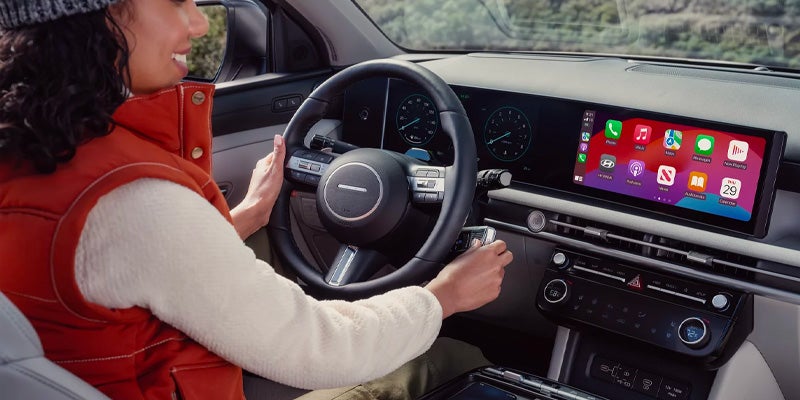  A woman in a car using the dashboard touchscreen.